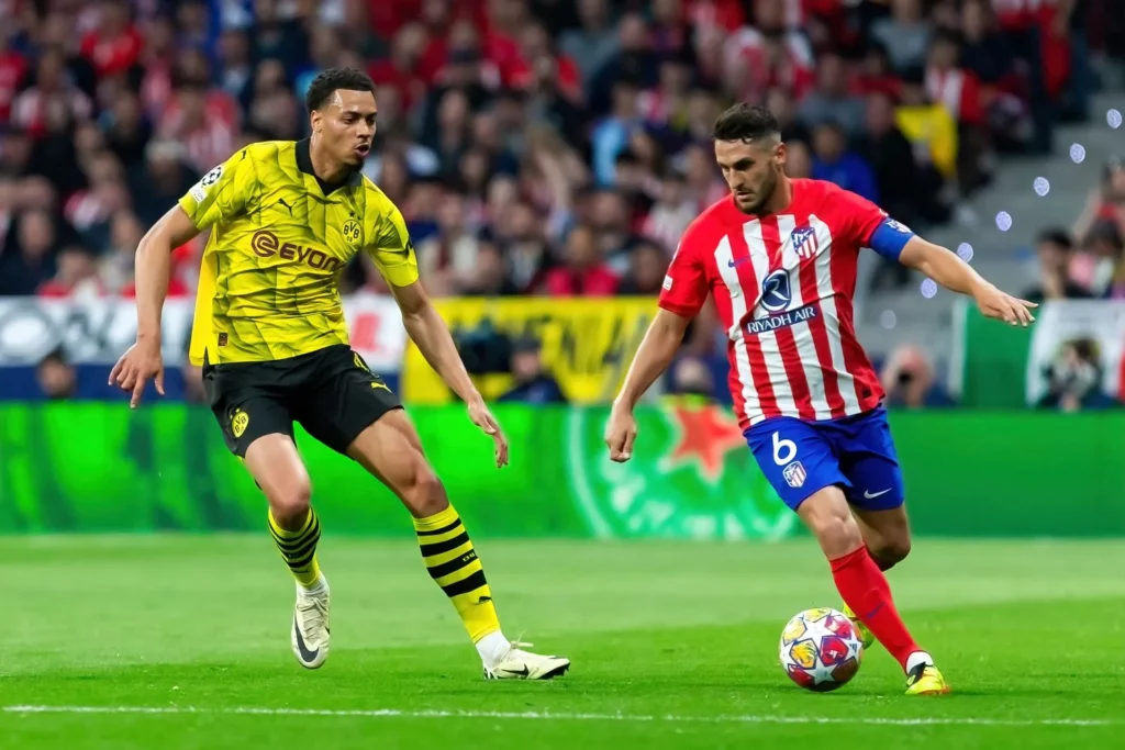 Spieler von Borussia Dortmund und Atlético Madrid im Laufduell