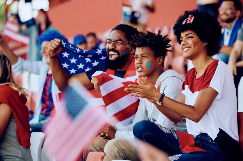 US-amerikanische Familie mit Flagge und Bemalung jubelt im Stadion