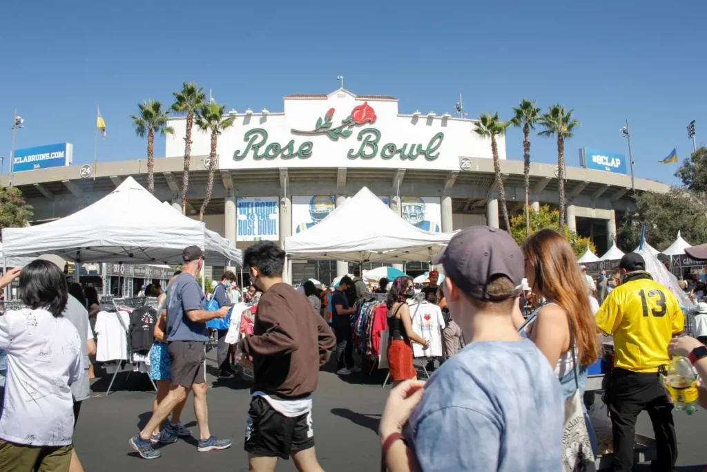 Mehrere Menschen bei sommerlichem Wetter vor dem Eingang zum traditionellen Rose Bowl Stadium