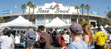 Mehrere Menschen bei sommerlichem Wetter vor dem Eingang zum traditionellen Rose Bowl Stadium
