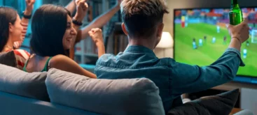 Mehrere junge Fußballfans schauen Fußball im Fernsehen und jubeln