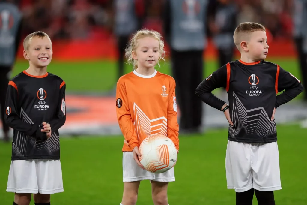 Foto von drei Einlaufkindern vor dem Spielbeginn