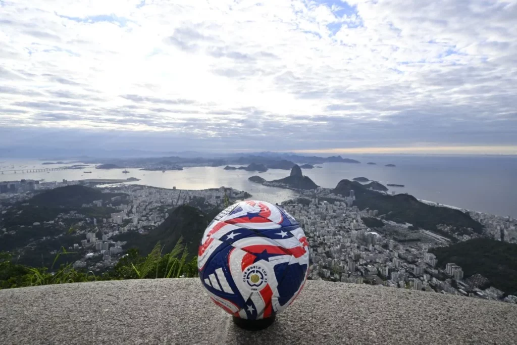 Fußball mit Logos der Klub Weltmeisterschaft liegt auf einem Berg mit Ausblick auf eine Stadt