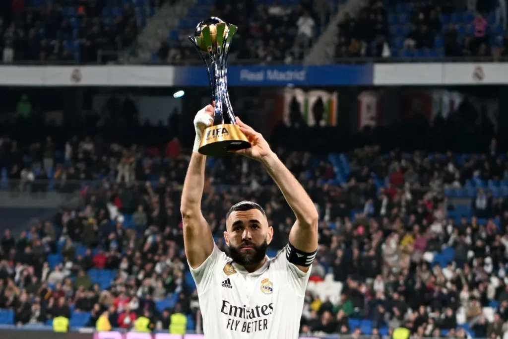 Karim Benzema feiert mit einer Trophäe in der Hand einen Sieg bei einer früheren Klub WM