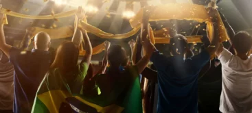 Menschenmenge hält Fan-Schals von Klub WM Teilnehmern hoch und jubelt im Flutlicht