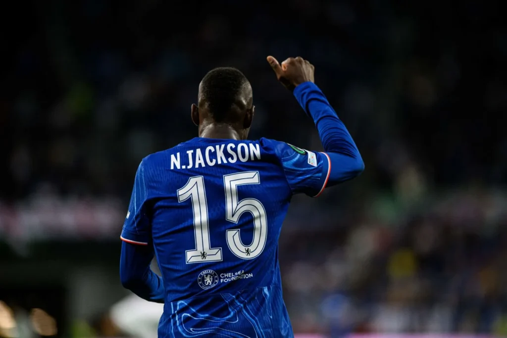 Nicolas Jackson, im Chelsea-Trikot mit der Rückennummer 15, mit dem Rücken zur Kamera hebt den rechten Daumen empor