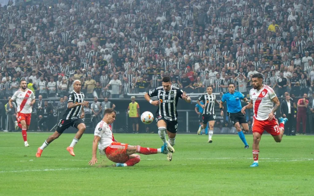 Fußballspieler von River Plate steigt mit einer harten Grätsche gegen einen Gegenspieler ein